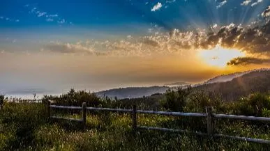 vista de un campo con el sol de fondo representando el transito de la muerte un viaje de vuelta a casa no un final
