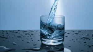 Vertiéndose agua en un vaso, simbolizando El que beba del agua que yo le daré, en su significado espiritual.