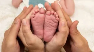 pies de bebe y manos sujetando de mujer y hombre en representación de la creación el propósito existencial