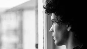 hombre mirando por ventana pensando escuchar mi propia verdad quién soy