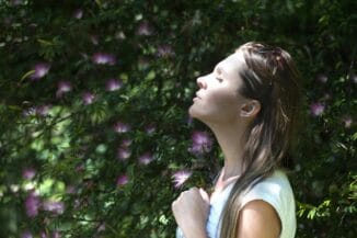 Mujer meditando en calma, con un aura de paz para salir de la ilusión del ego